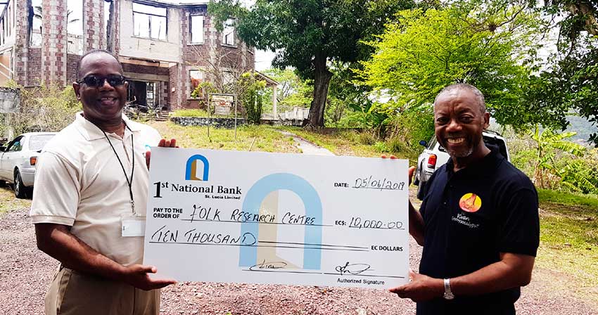 Image of 1st National Bank’s Executive Manager for Marketing and PR Robert Fevrier (left) presenting the cheque to FRC Founder Msgr. Patrick Anthony. 