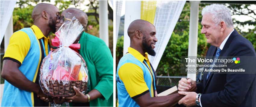 Image: (L-R) Javelin thrower Albert Reynolds gets a hug and a fruit basket from SLOC President Fortuna Belrose; Saint Lucia’s Prime Minister Allen Chastanet extends his hospitality to Reynolds with a weekend for two at the Coco Palm Hotel. (Photo: Anthony De Beauville) 