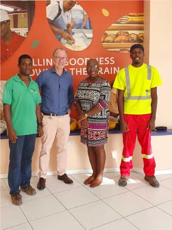 Image of Managing Director of Caribbean Grains Ltd, Arnaud de Moussa (second from left) and Minister Dr Gale Rigobert with Caribbean Grains team members. 