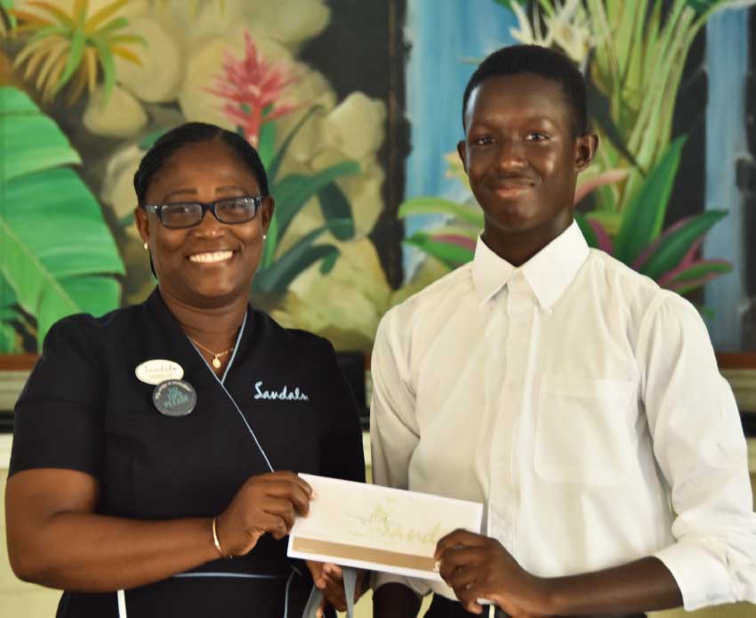 Image: Shaquil Flavius receiving his scholarship pack from Versilia Jn Baptiste, Front Office Supervisor, Sandals Halcyon Beach Resort. 