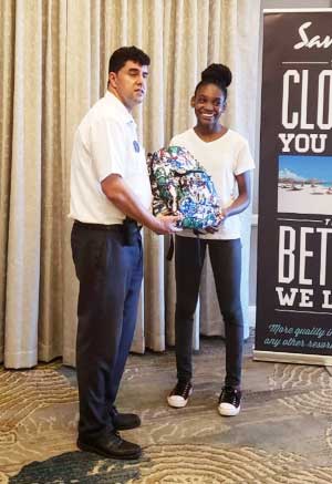 Image of Tiffany Florent receiving her Sandals Foundation scholarship from Rui Freitas, Hotel Manager, Sandals Regency La Toc Golf Resort & Spa. 