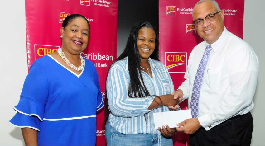 Image: CIBC FirstCaribbean’s Managing Director, Retail and Business Banking Mark St Hill (right) making the presentation to Tamika Roberts, President of the Bahamas Students Association (centre) while Business Development Officer at UWI Cave Hill, Sonia Johnson shares in the moment.