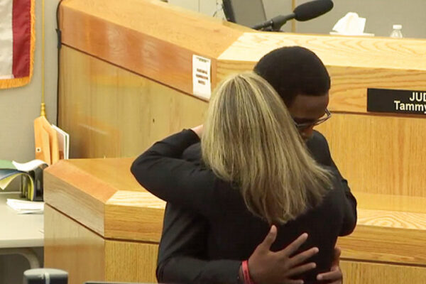 Image of Botham’s younger brother Brandt embracing Amber Guyger