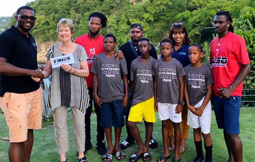 Image: Monchy FC President, Charde Desir receiving the cheque for EC$10,000 from Helen Gobat. (PHOTO: CD)