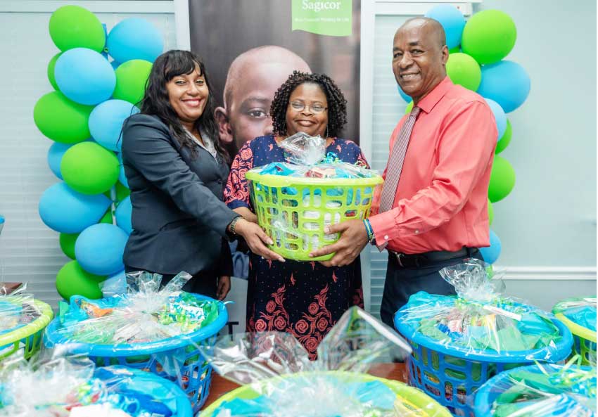 Image: The Sagicor Team presents Tanzia Toussaint, Deputy Director of Social Transformation at the Ministry of Equity, Social Justice, Local Government and Empowerment with a donation of hampers. From left: Gillian Polius, Branch Administrator, EC Operations, Sagicor General; Ms Toussaint; Eon Phillips, Assistant Vice President, EC Insurance Operations, Branch Manager and Principal Representative for Sagicor Life (Eastern Caribbean) Inc.