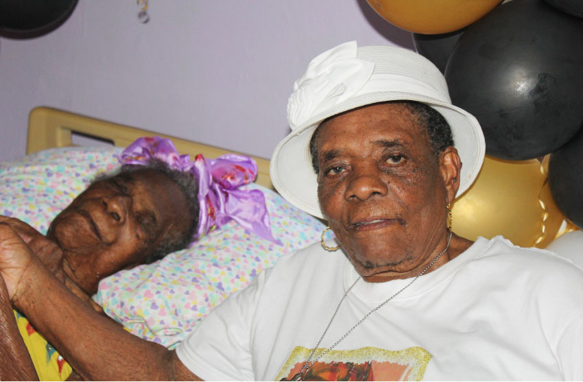 Image of Angela Williams (left) with her daughter Mary Etienne at her home in Old Belair last Sunday.