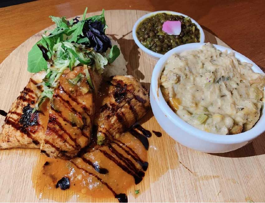 Image: Beer batter roasted chicken with coffee BBQ sauce served with green banana gratin, coconut herb rice, fresh cucumber salad and Lucian style lentils.