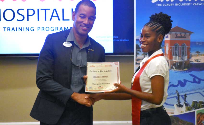 Image: Christopher Elliott, General Manager at Sandals Halcyon awarding certificate to graduate.