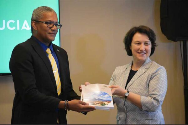 Image of ITC Director and Chief Economist Marion Joseph (R) handing o Commerce Minister Bradley Felix the NES docunment.