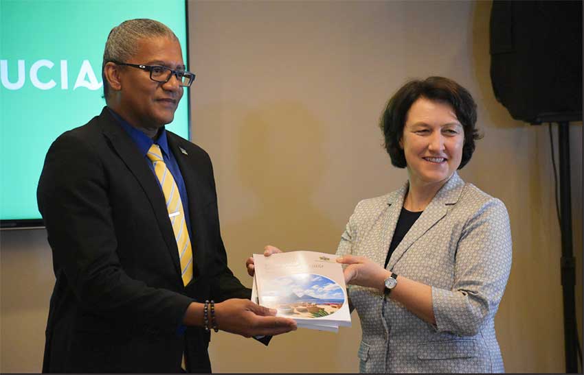 Image of ITC Director and Chief Economist Marion Joseph (R) handing o Commerce Minister Bradley Felix the NES docunment.