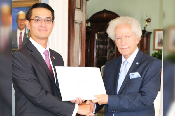 Image of Governor General, His Excellency Sir Emmanuel Neville Cenac, accepting the Letters of Credence from Ambassador Chen.