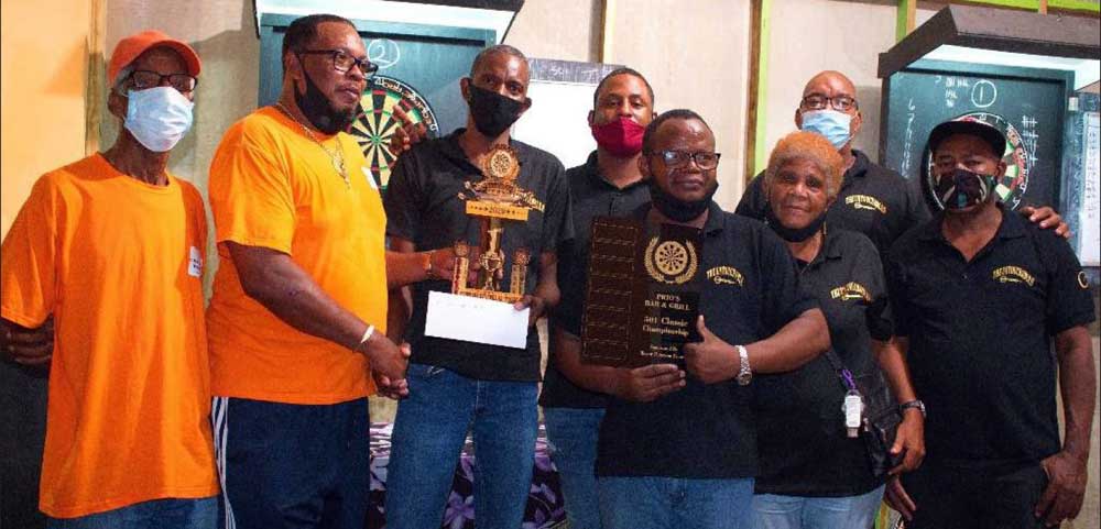 Image: Champion team, Untouchables A, Trevor John third left receiving the championship trophy from Denis ‘Prio’ Louis. (PHOTO: MM) 