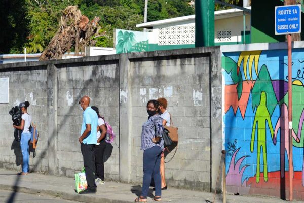Image: Commuters waiting for a bus at an empty Gros Islet bus terminal yesterday.