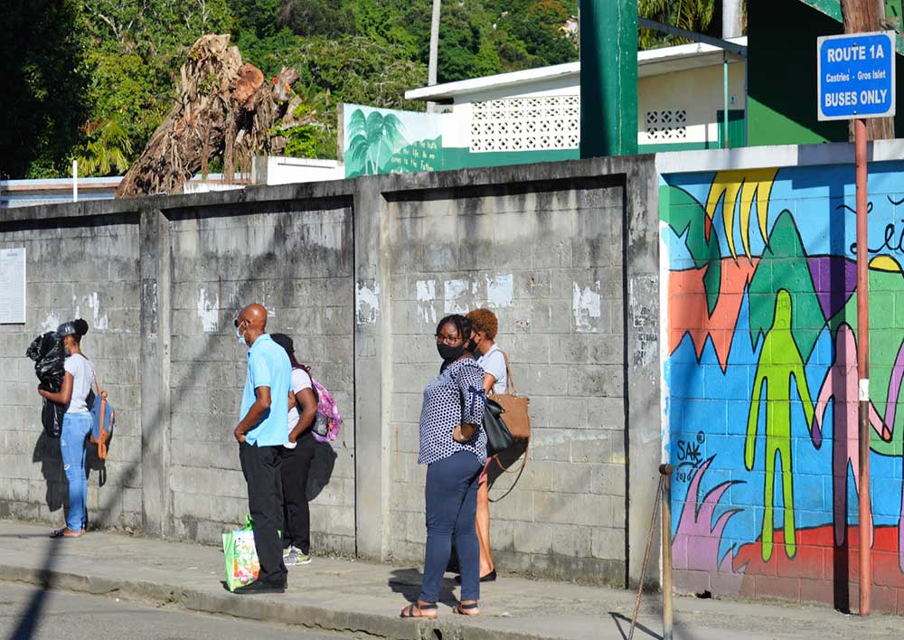 Image: Commuters waiting for a bus at an empty Gros Islet bus terminal Tuesday. (PHOTO: Anthony De Beauville)