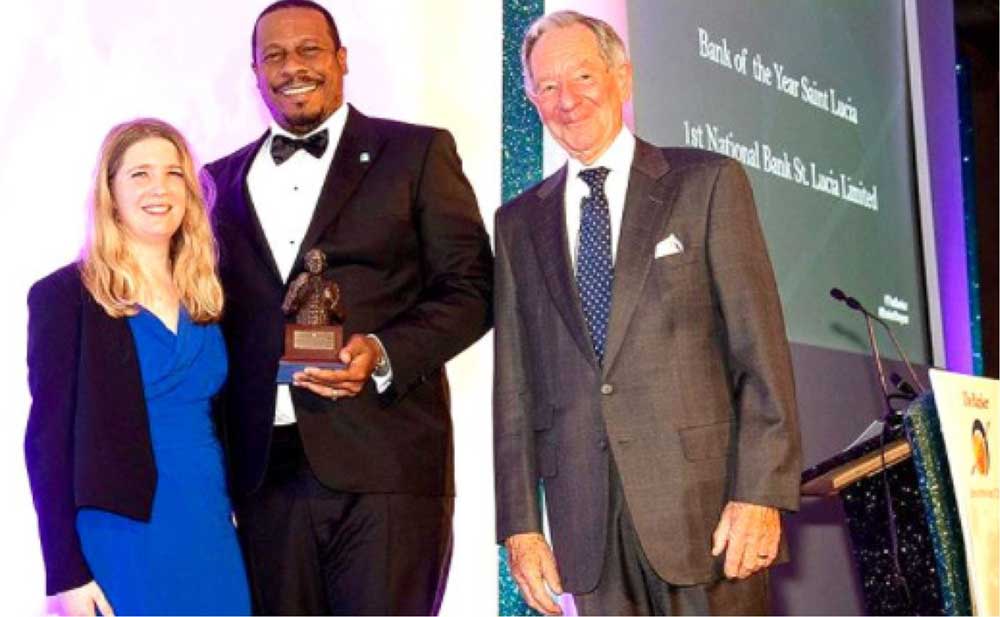 Image of Mr Johnathan Johannes (centre) receiving the award for Saint Lucia on behalf of 1st National St. Lucia Limited at the Banker Magazine’s Bank of The Year 2019 Awards.