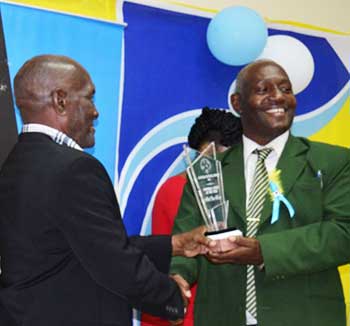 Image: (L-R) Albert ‘Vasso ‘ receiving an award from SLFA 1st Vice President, Emmanuel Belase PHOTO: Anthony De Beauville)
