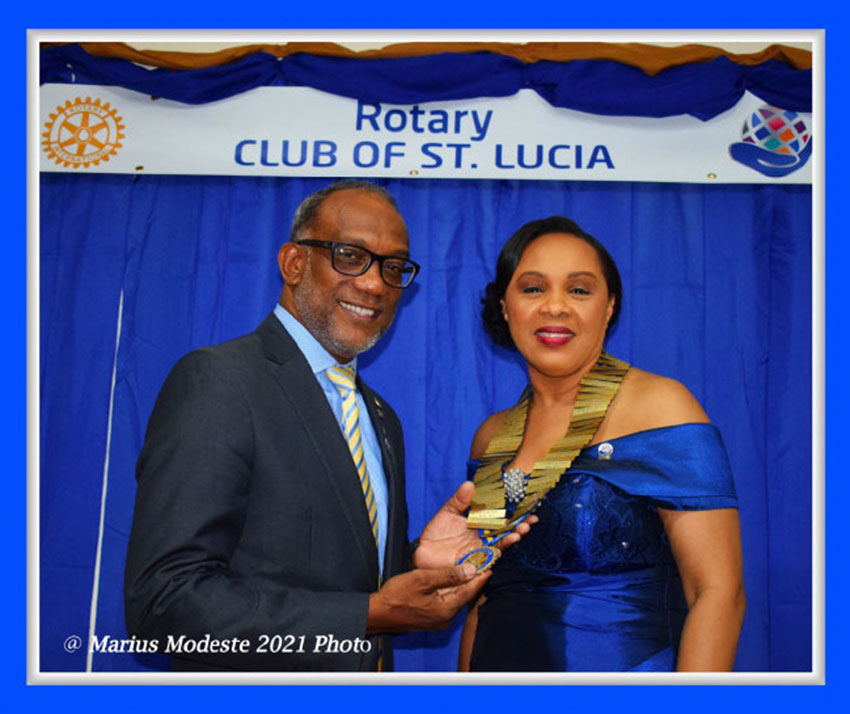 Leathon Khan passing on the heavy golden presidential chain to the former club treasurer Keturah Donai.