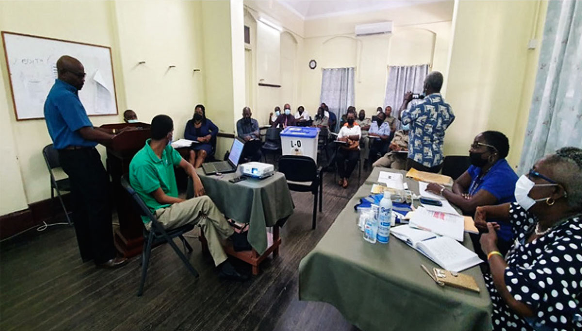 Police officers and electoral department officials at a meeting.