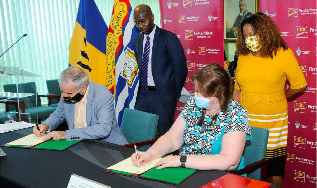 CIBC FirstCaribbean’s Chief Executive Officer Colette Delaney signs a copy of the MOU as does Principal of the Cave Hill campus of the UWI, Professor Clive Landis while the bank’s Director of Corporate Communications Debra King and Deputy Principal of Cave Hill campus Professor Winston Moore observe.
