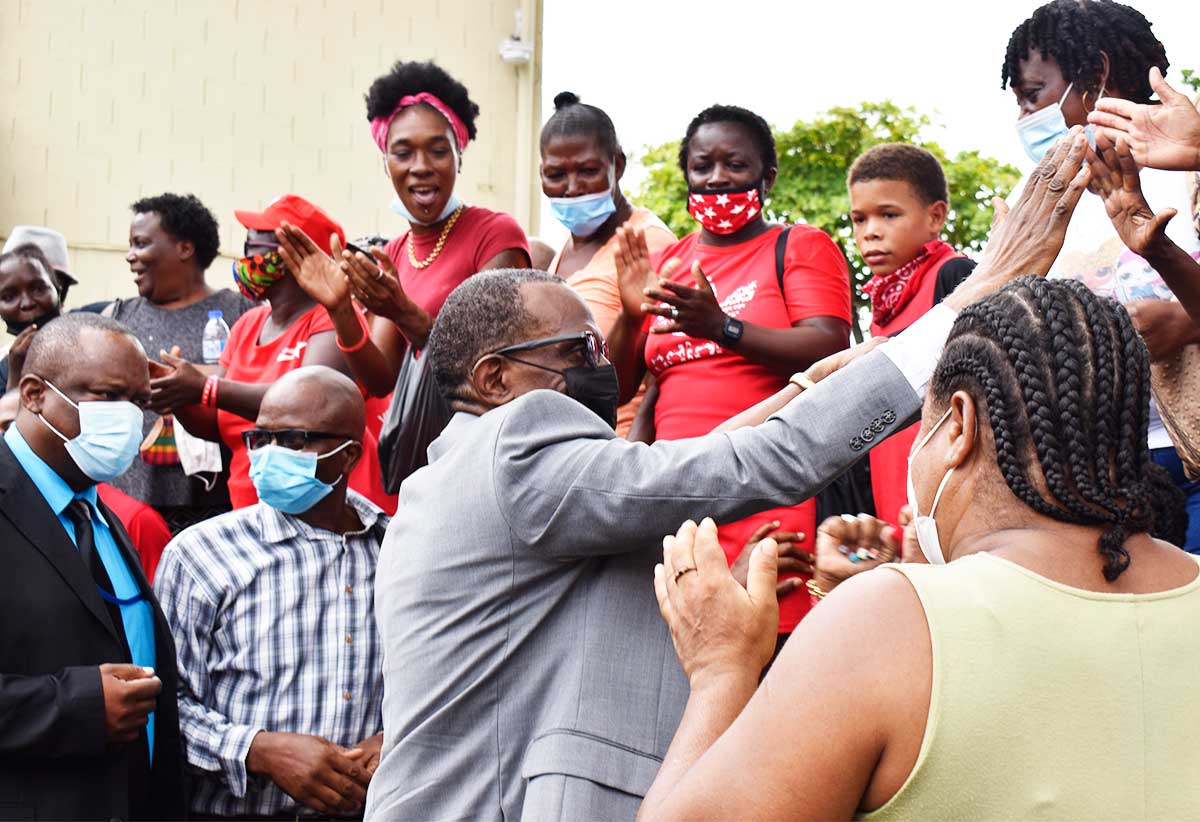 Prime Minister Philip J Pierre high-fiving supporters