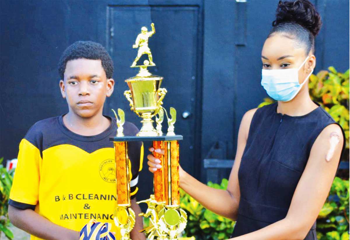 (L-R) The winning captain, Theiry Morille receiving the Championship trophy and gold medals from Guardsman (Saint Lucia) Limited representative, Tember Cadet, the 2021 champions, Northern United FC. (Photo: Anthony De Beauville) 