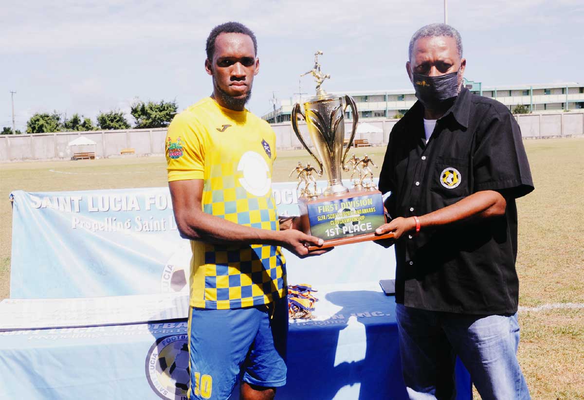 Platinum FC captain Gregson President (L) holding the Chmpionship trophy.