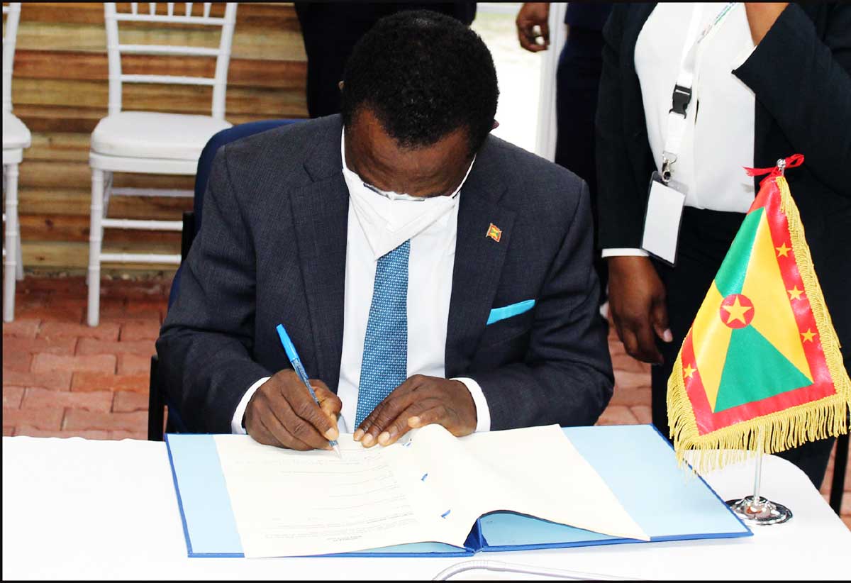 Grenada PM signing the protocol.