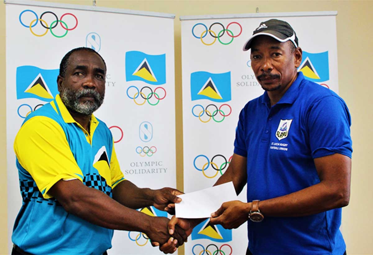 (from left and right) – SLOC Inc. President Alfred Emmanuel presenting a cheque to SLRFU’s Technical Director, Wayne Pantor.