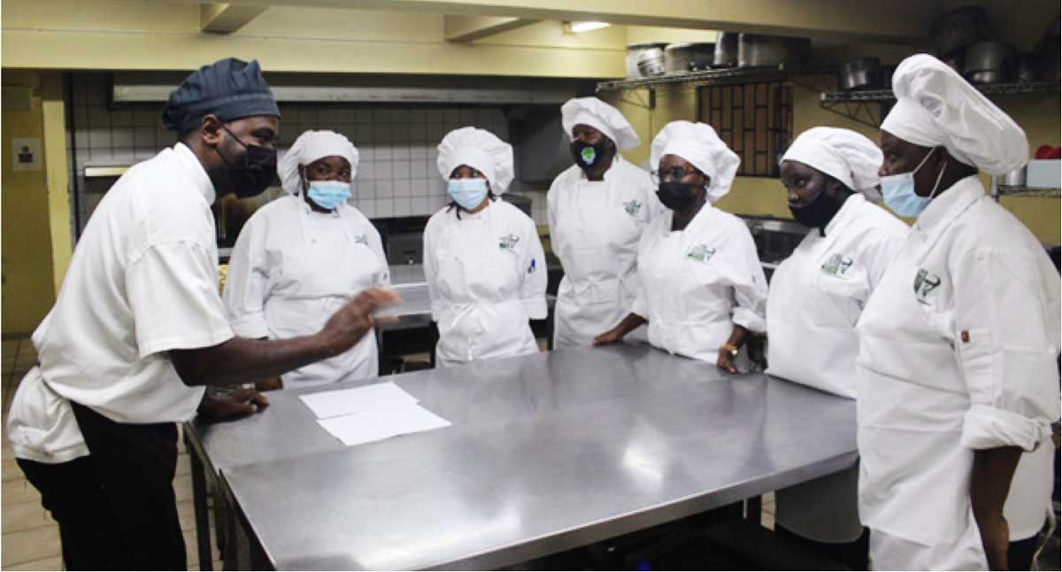 Instructor from SALCC (left) teaching students skills in the Hospitality vocational training course.