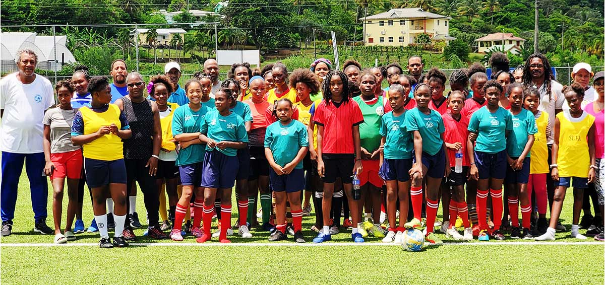 Coaches, coordinators and players gather for a photo-opportunity at the Technical Centre during the Girls Football Fiesta program.