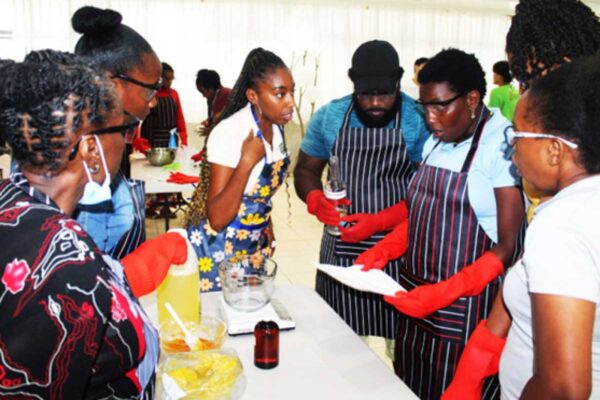 Workshop facilitator Shakira Roberts (in flowered apron) explaining the soap-making process to participants.