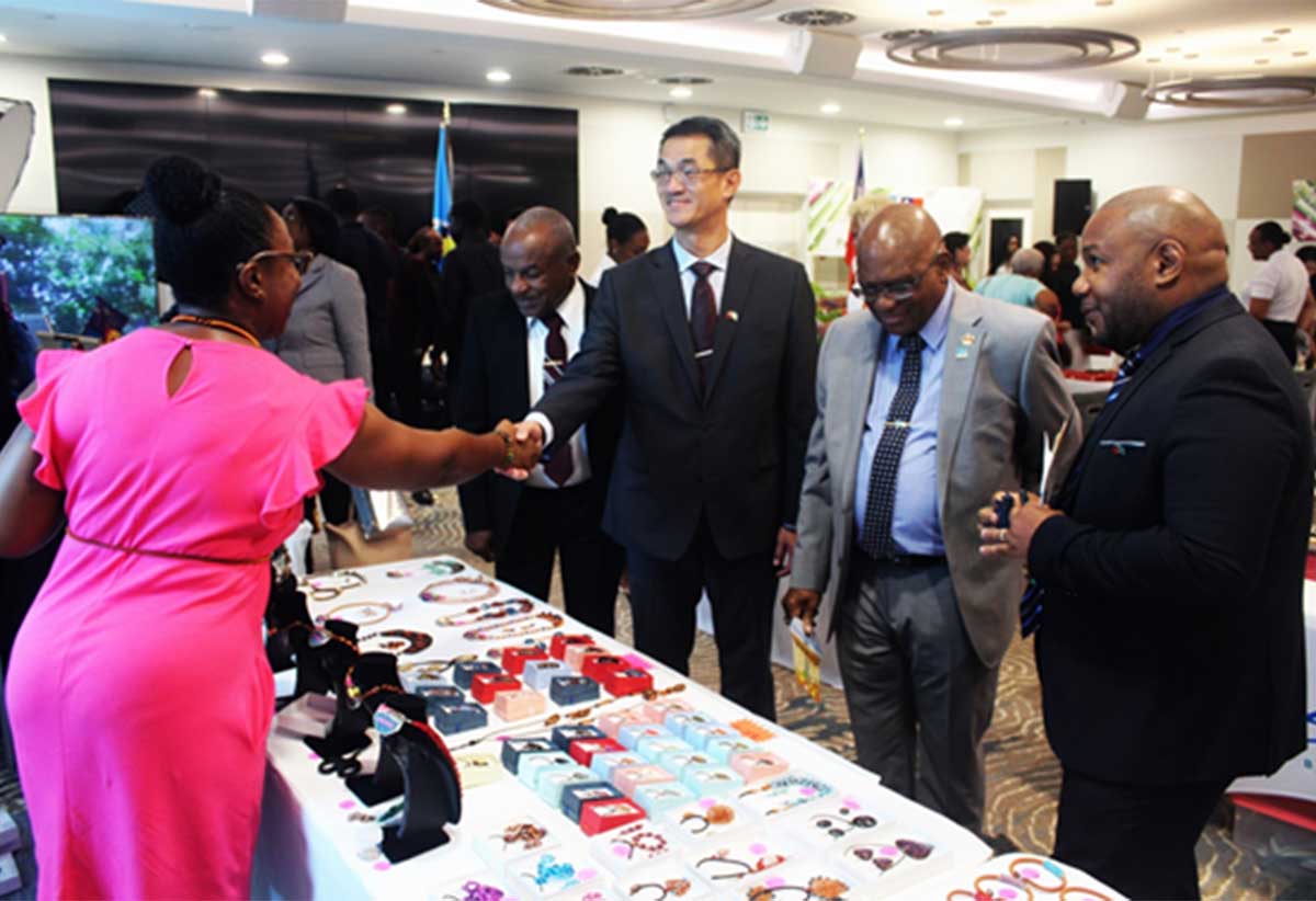 Ambassador Chen and His Excellency Cyril Charles, Acting Governor General, greeting one of the Saint Lucian exhibitors at the trade exhibition.