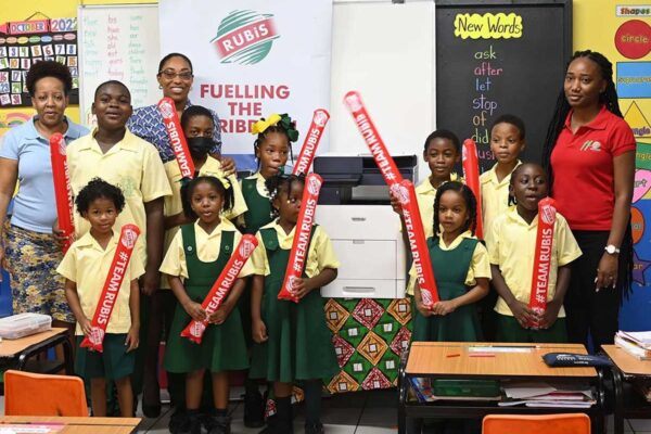 (L-R back row) Teacher at Balata Primary, Virginia Williams during the handing over of the photocopier from Chriselda Norbal and Tamika Celestin, RUBIS and some of the excited students.