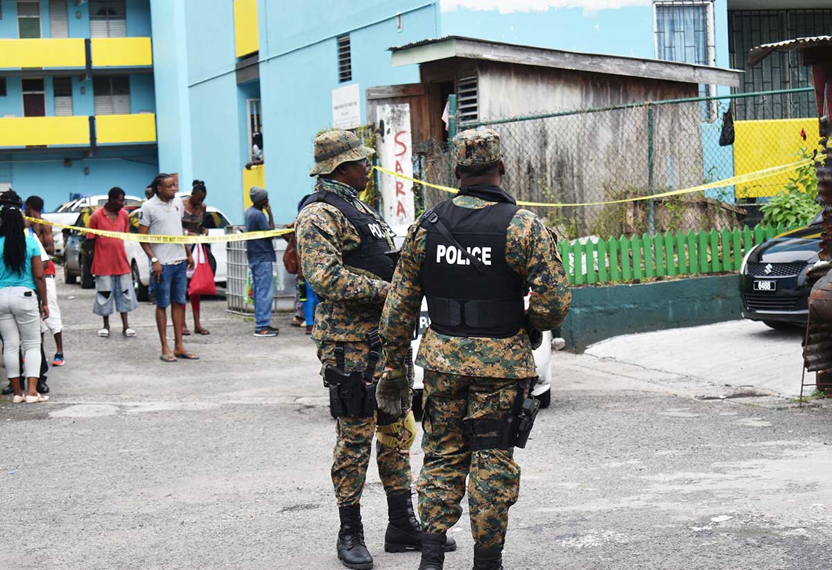 Police, onlookers and crime scene experts at the scene of this morning's shooting.