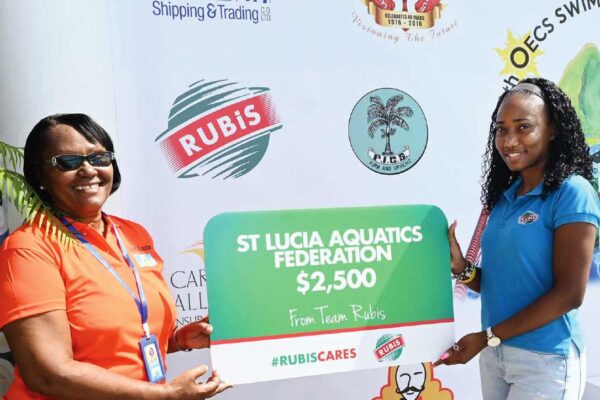 Tamika Celestine, Assistant Accounts Executive at RUBIS (right) presenting to Paula James, Vice President Administration of the St. Lucia Aquatics Federation (SLAF).
