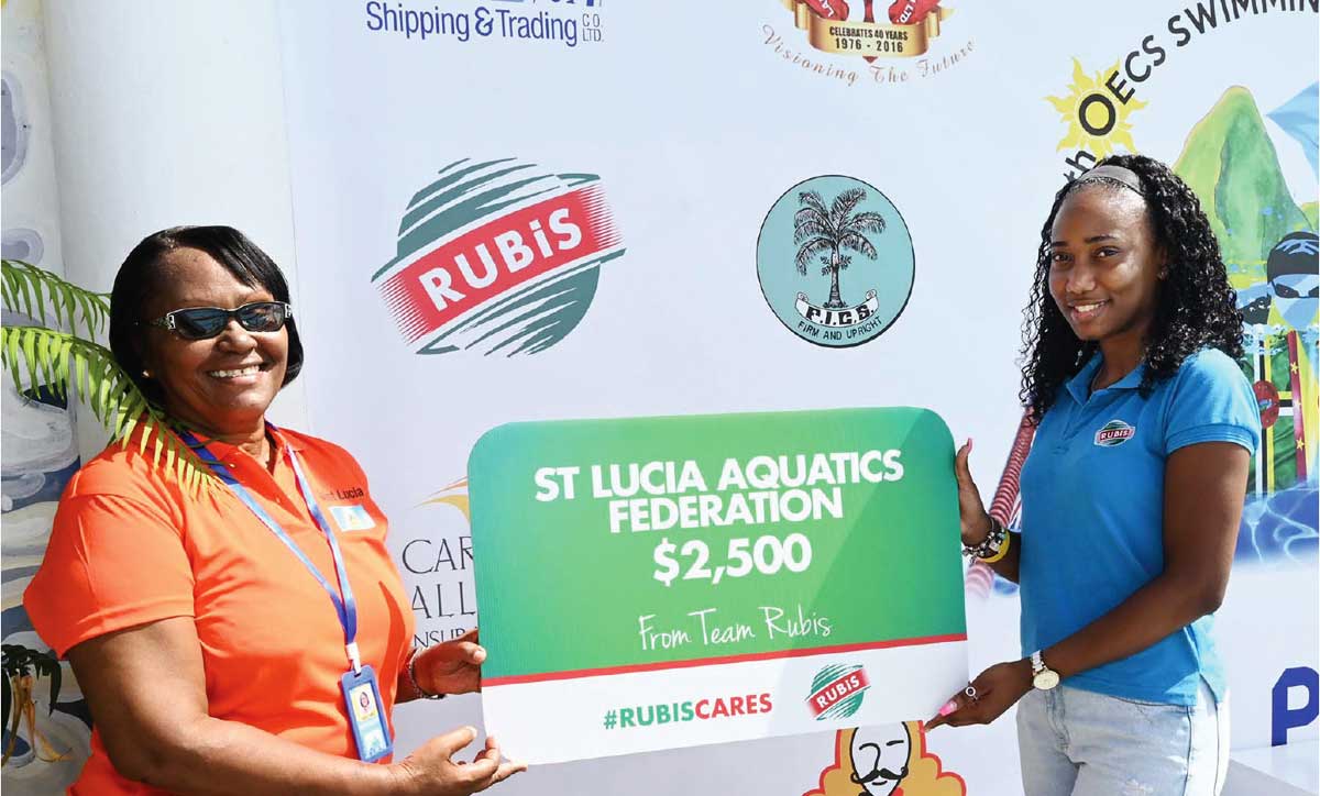 Tamika Celestine, Assistant Accounts Executive at RUBIS (right) presenting to Paula James, Vice President Administration of the St. Lucia Aquatics Federation (SLAF).