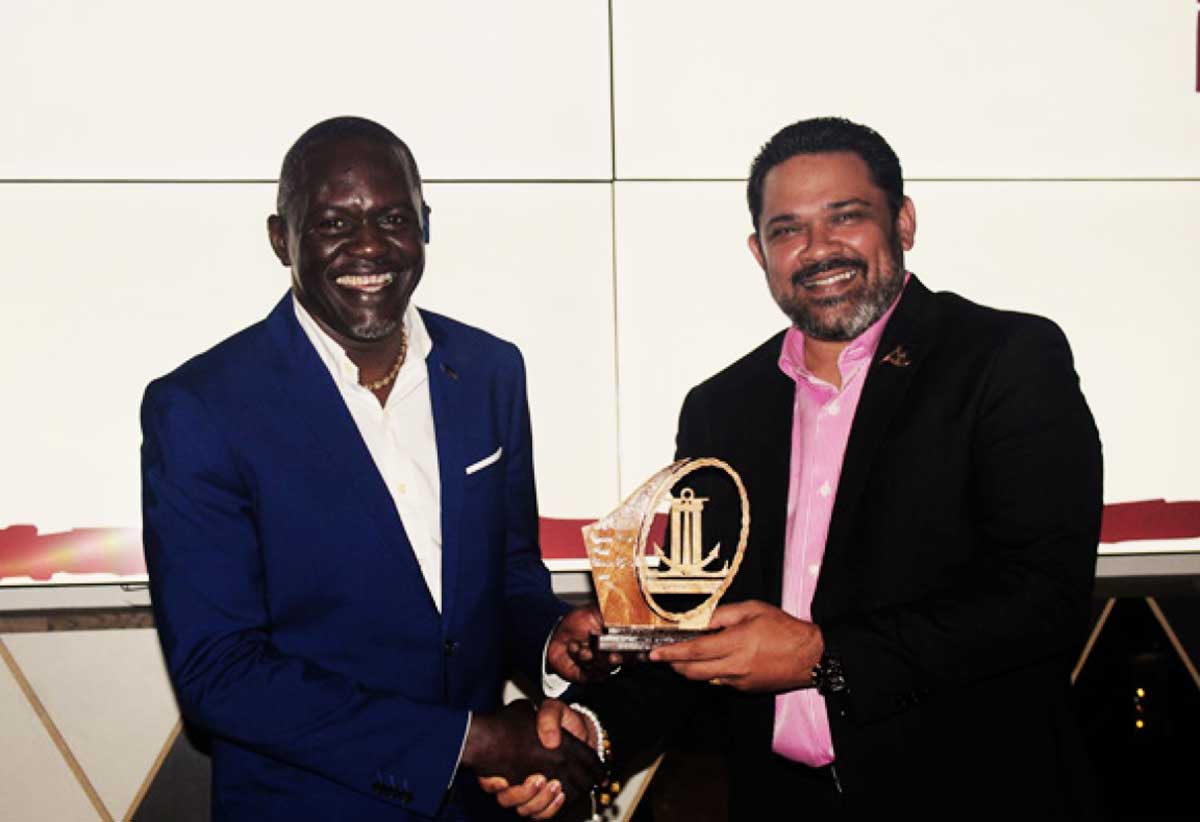 Sen. Noorani Azeez, CEO of the Saint Lucia Hospitality & Tourism Association (SLHTA), right, presents an award to one of the winners at the staff awards ceremony.