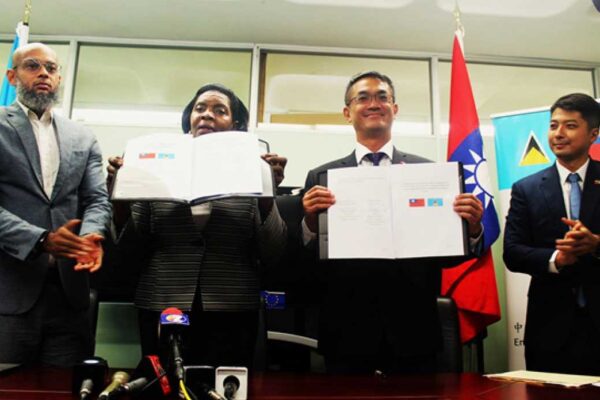His Excellency Peter Chia-yen Chen, Taiwan’s Ambassador to Saint Lucia, and Hon. Emma Hippolyte, Minister for Commerce, Manufacturing, Business Development, Cooperatives and Consumer Affairs, at the June 13, 2023, MoU signing ceremony in the Ministry of Commerce conference room. At far left is Mr. Dylan Norbert Inglis, Legal Officer, Ministry for Commerce, Manufacturing, Business Development, Cooperatives and Consumer Affairs, while at far right is Mr. Daniel Lee, Head of Taiwan Technical Mission (TTM) in Saint Lucia.