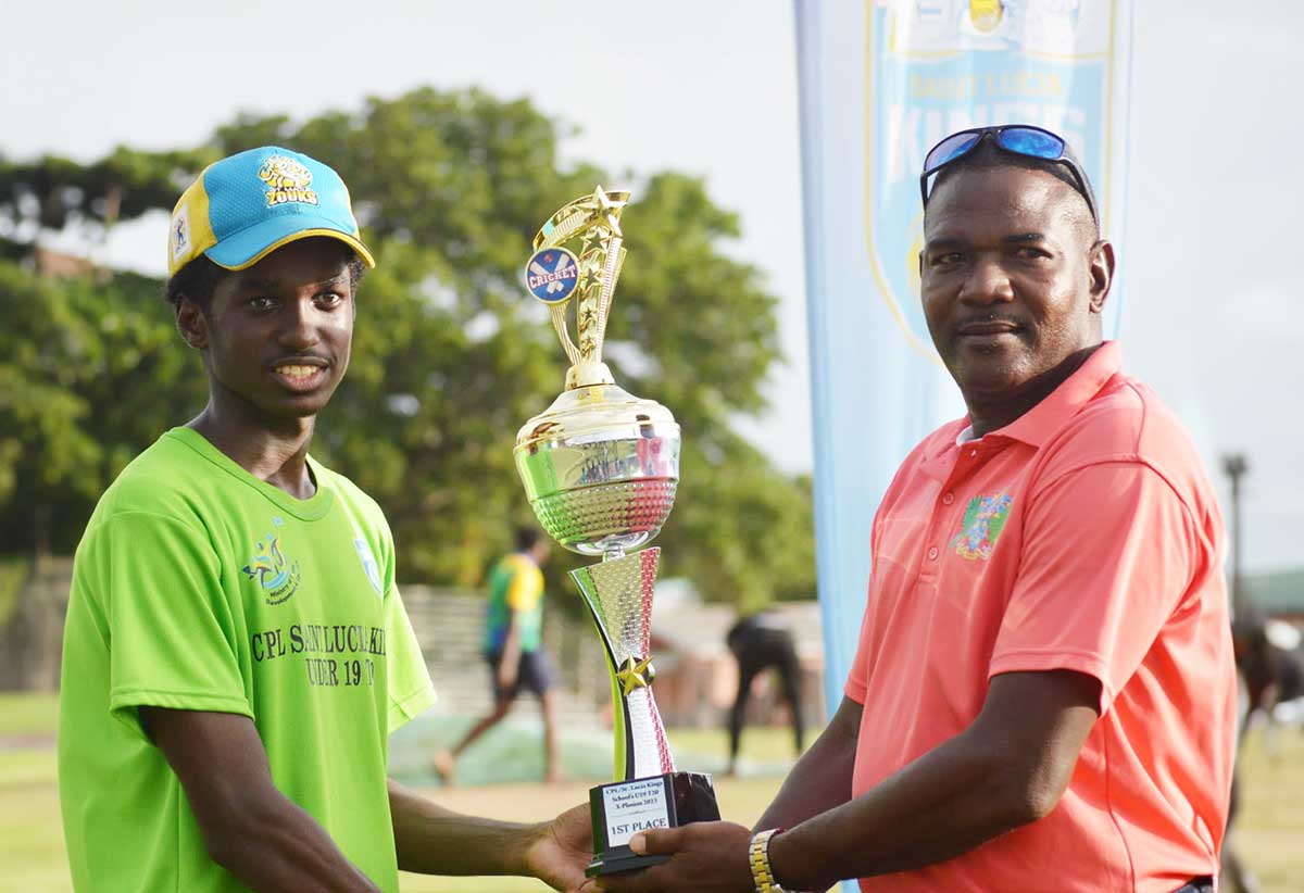 Strikers’ Captain Amari Venner collects winner’s trophy from coach Alton Crafton.