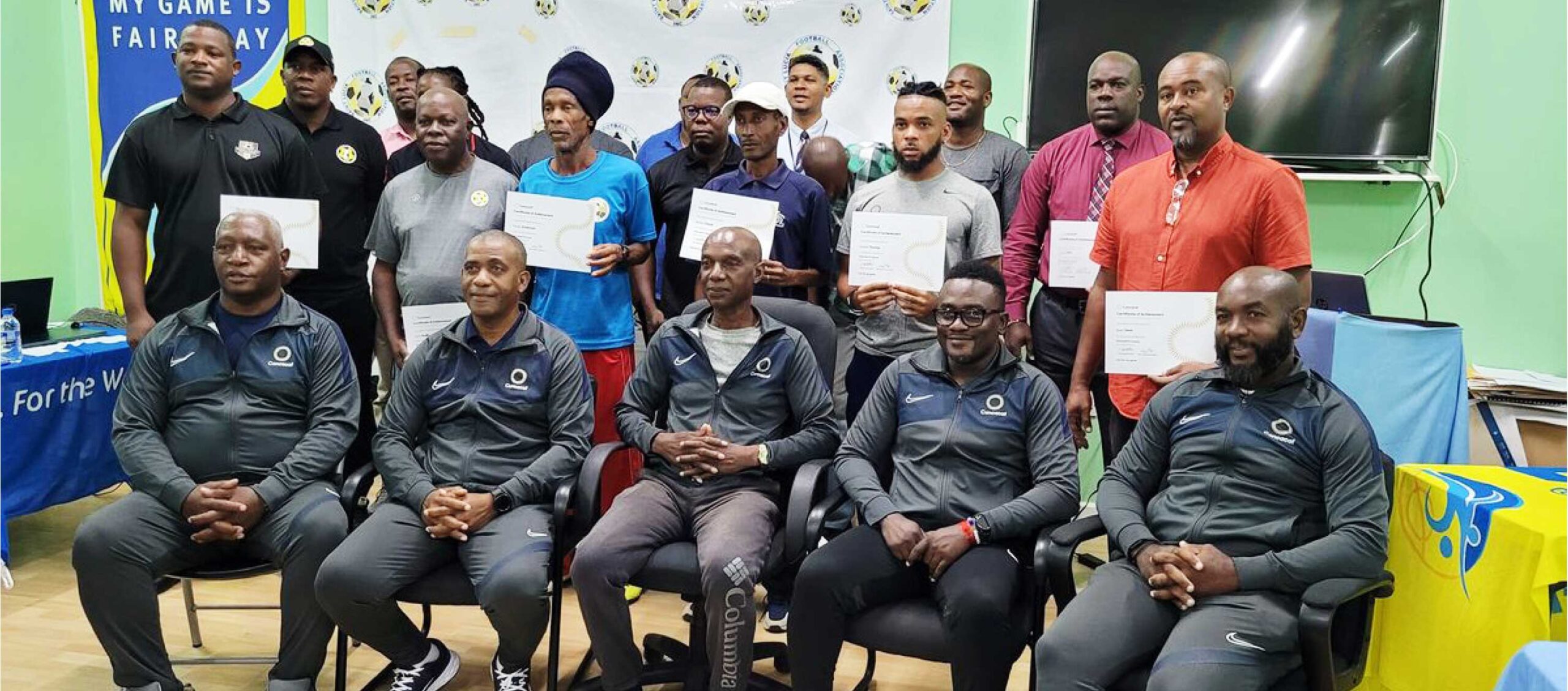CONCACAF facilitators, SLFA officials and Certified Coaches display their certificates. 