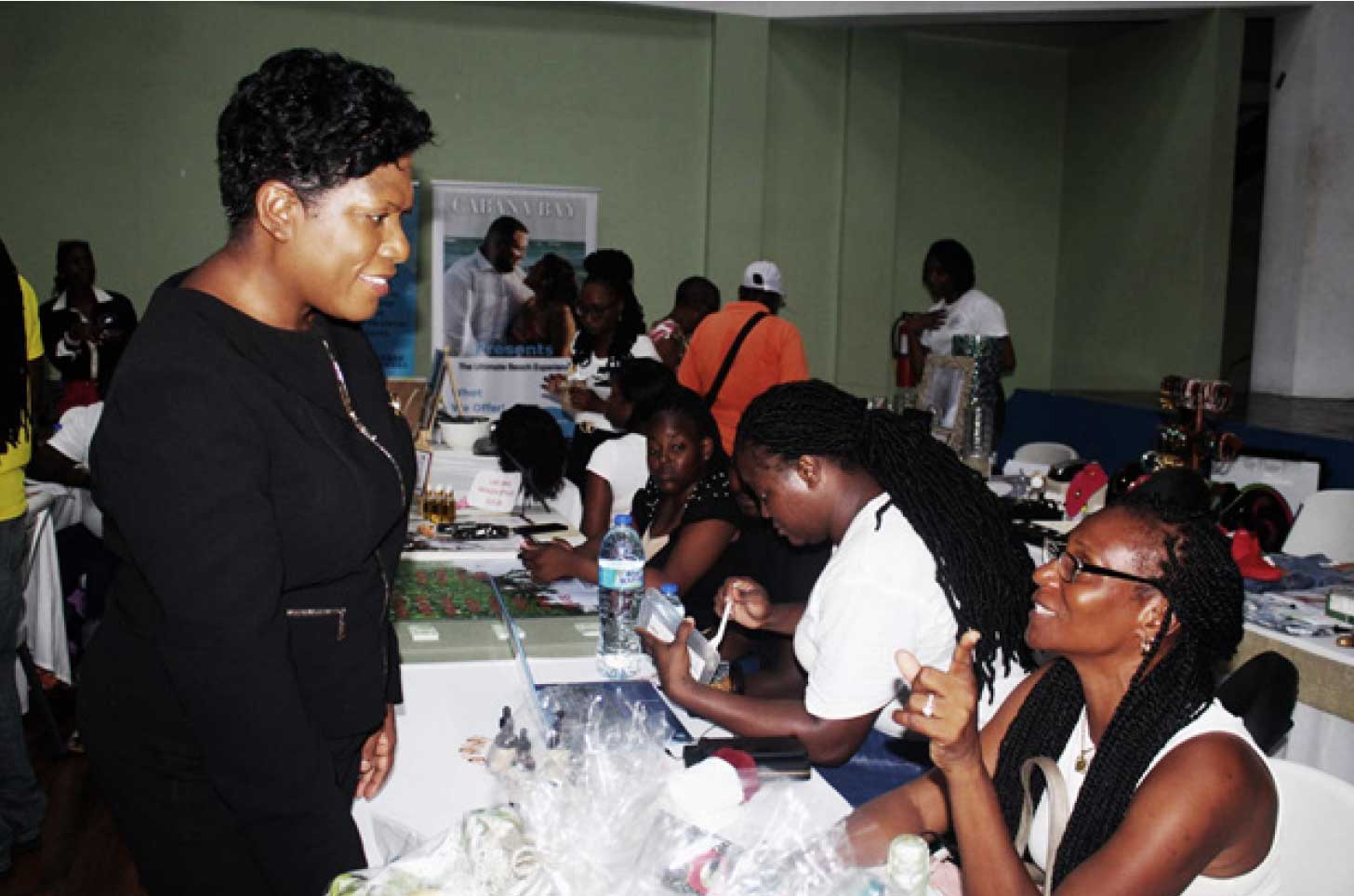 Permanent Secretary in the Office of the Prime Minister, Ms. Esther Rigobert, left, engages one of the participants at the Entrepreneur Showcase.