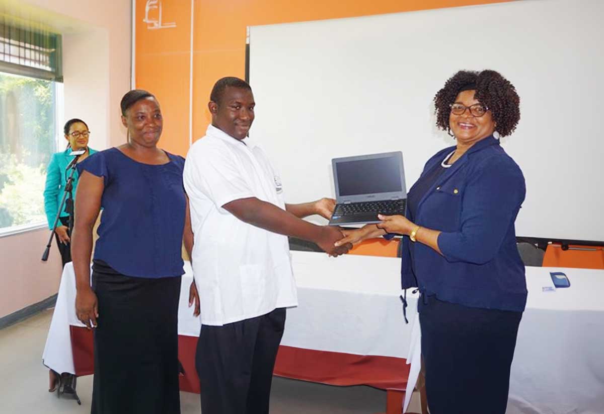 PS Pauline Antoine-Propsere presents a laptop to a secondary school student 