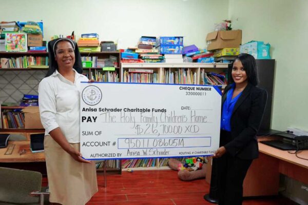 Sister Antonia David, Administrator of the Holy Family Children’s Home receives donation from Anisa Schrader
