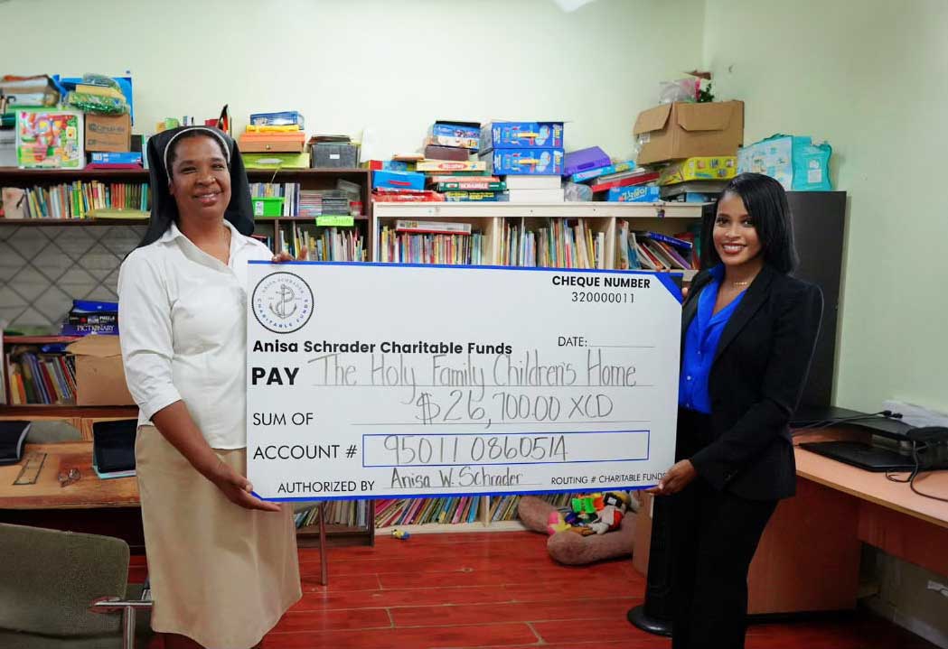 Sister Antonia David, Administrator of the Holy Family Children’s Home receives donation from Anisa Schrader