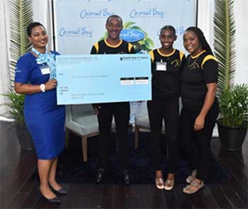 Gemma Edwin, Finance Manager at Coconut Bay Beach Resort & Spa presents a $5,000 check to support the Pace Setters sports team. Pictured (Left to Right): Gemma Edwin, Finance Manager at Coconut Bay Beach Resort & Spa; Claude Charlemagne, President of the Pace Setters; Pace Setter athlete Niomi London and her mother.