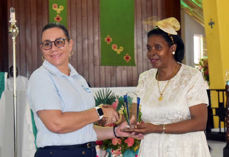 Charon Gardner-Hippolyte, Company Director, Carasco & Son, receiving an award from Minister for Commerce Emma Hippolyte