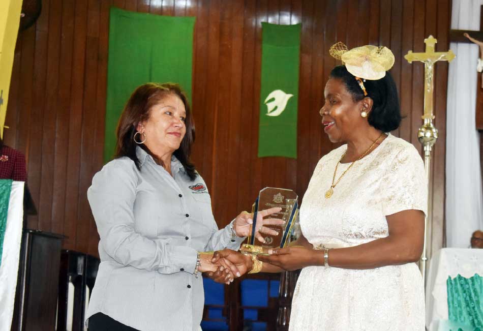Managing Director of Renwick & Company Cheryl Renwick accepting an award on the company’s behalf from Commerce Minister Hippolyte
