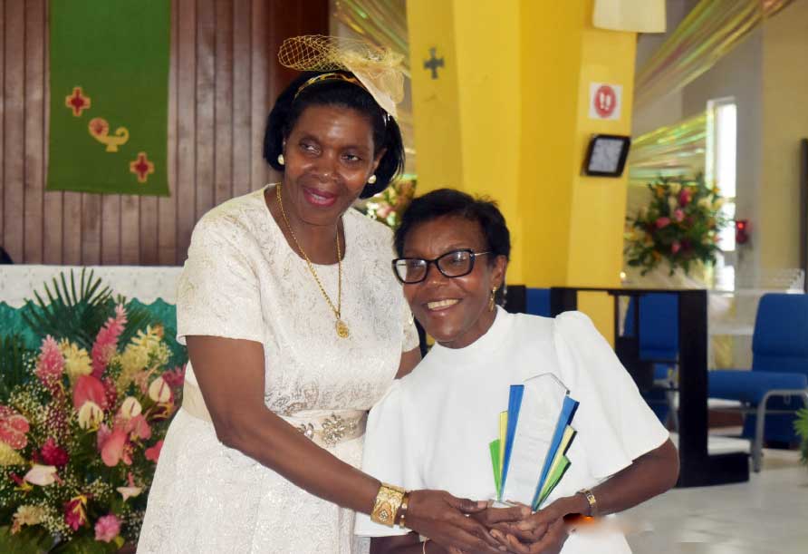 Min. for Commerce Emma Hippolyte (L) posing with Althea Valmont, Director, A.F. Valmont and her award