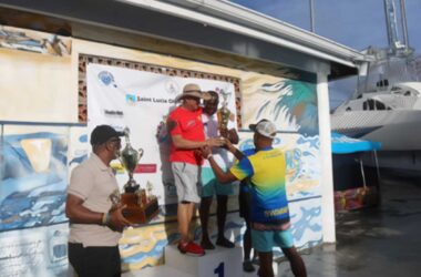Manager of team Antigua and Barbuda, Kem Warner (right) and coach Nelson Molina accepts the championship trophy at the 31st OECS Swimming Championships held in St Lucia