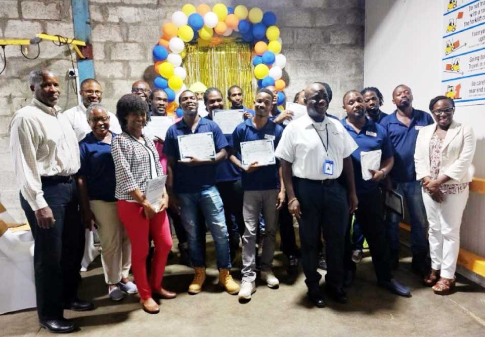 Mr. Kemuel Jn. Baptiste, Deputy Director of Agriculture Services in the Ministry of Agriculture; Mr. Dunstan Demille, Perishables Manager, Massy Stores St. Lucia; Mr. Anthony Bristol, Director, Massy Stores St. Lucia; and Ms. Rosemary Etienne, Warehouse & Distribution, Massy Stores; and other Massy Stores staff with the participants at the graduation ceremony at Choc Warehouse on Tuesday, October 24, 2023.
